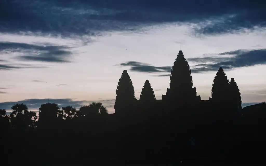Silhouette of Angkor Wat temple at dusk with dramatic sky