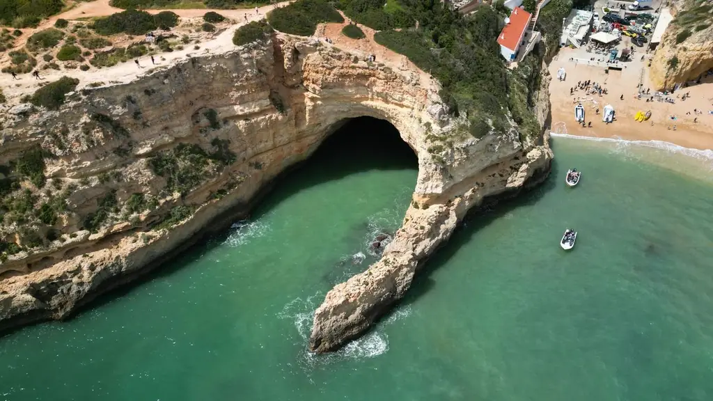 Stunning aerial shot of Benagil Cave with turquoise waters and sandy beach in Algarve, Portugal