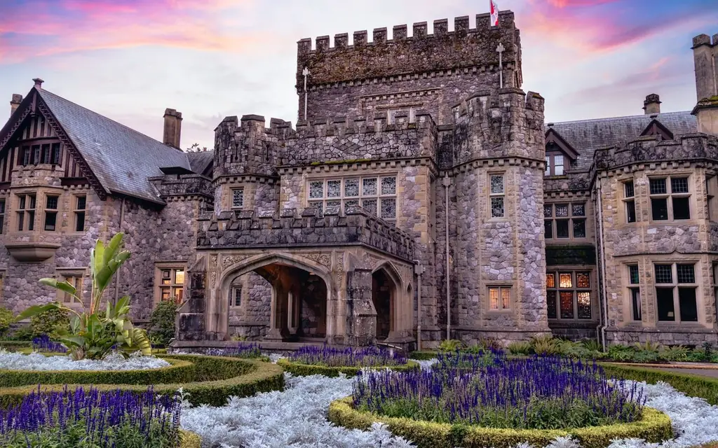 A beautiful castle in Victoria, BC captured at sunset, showcasing intricate architecture and vibrant gardens