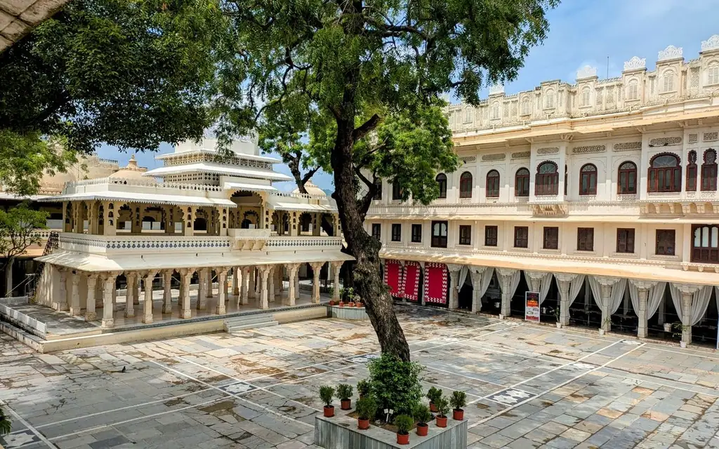 Stunning architectural details and vibrant greenery in the City Palace courtyard, Udaipur, India