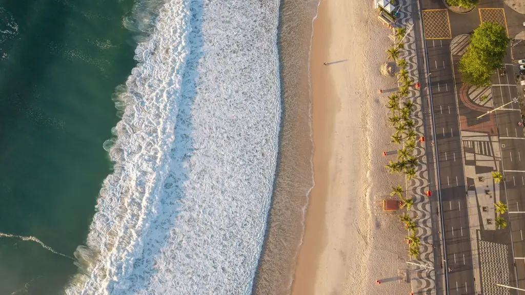 Stunning aerial shot of a Rio de Janeiro beach with golden sunlight highlighting the waves and coastline