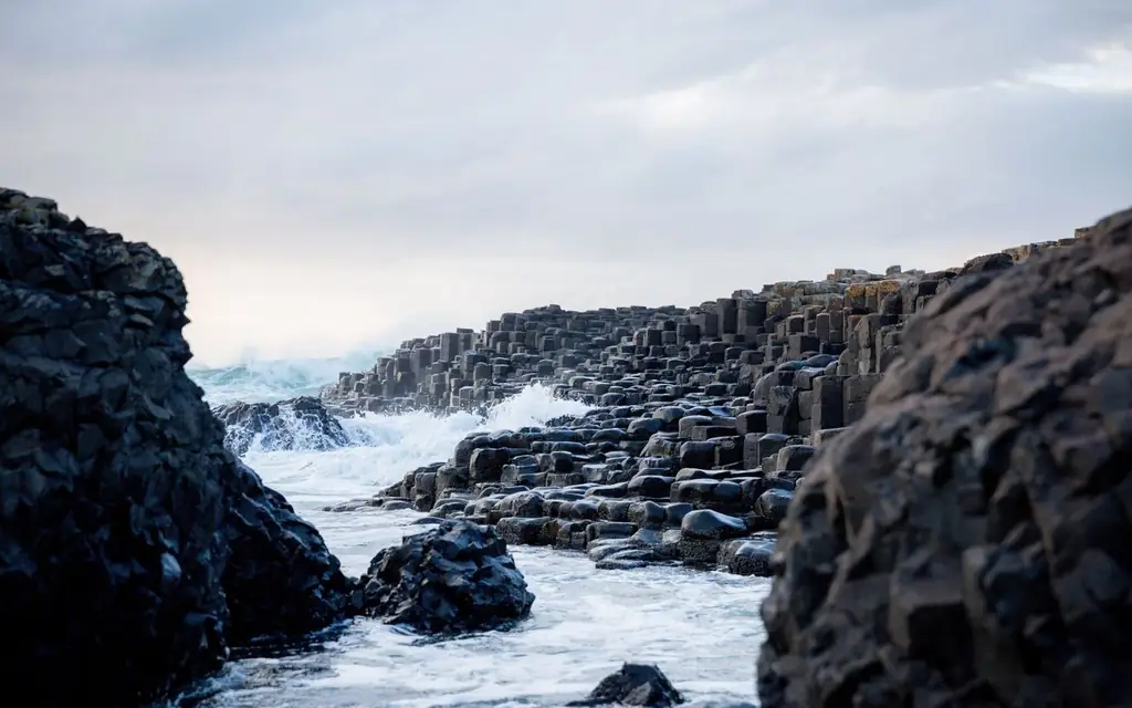 Majestic view of the Giant's Causeway with ocean waves crashing against basalt columns in Northern Ireland