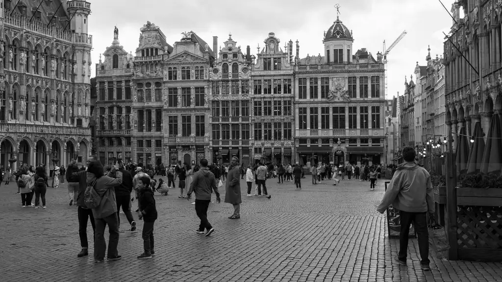 Black and white photo of Grand Place in Brussels with people strolling and historic architecture