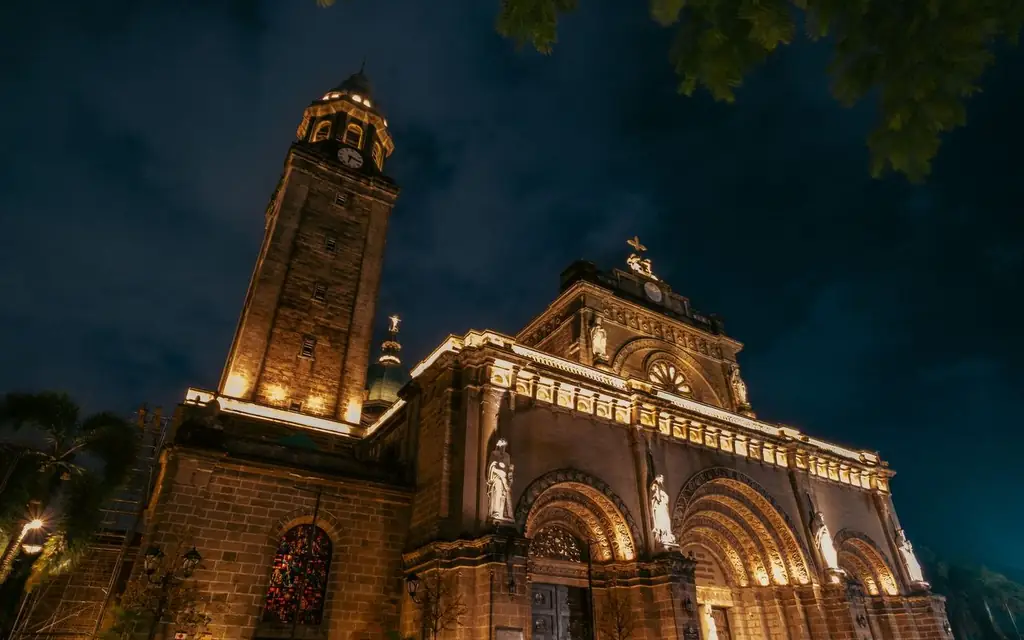 A dramatic night view of the illuminated Manila Cathedral showcasing its architectural beauty