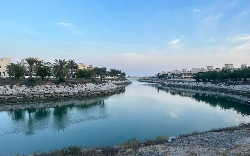 Beautiful canal amid residential area with palm trees in Ras Al-Khaimah, United Arab Emirates
