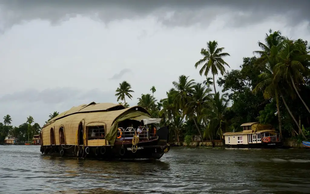 Scenic view of a traditional Kerala houseboat cruising through lush backwaters