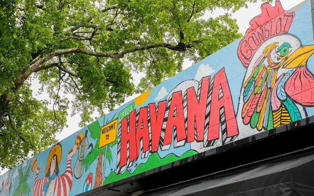 Vibrant mural in Havana featuring colorful rooster and lush greenery