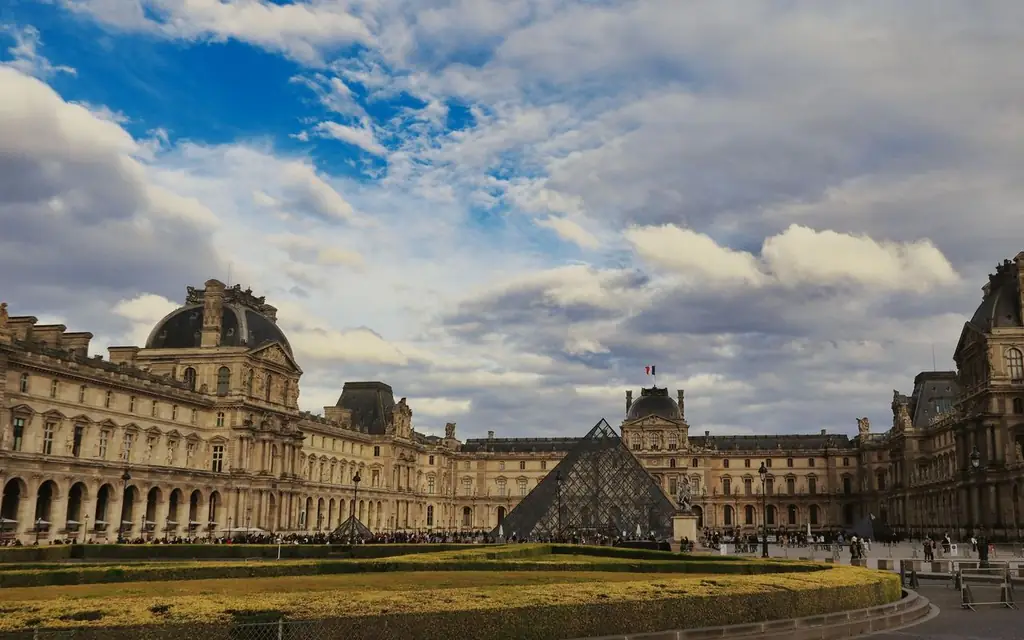 View of the Louvre Museum and its iconic glass pyramid in Paris, France