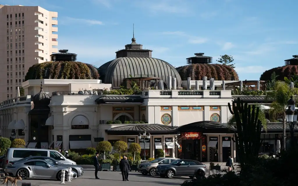 A sunny day view of the architecturally stunning casino in Monaco, featuring elegant domes and lush greenery