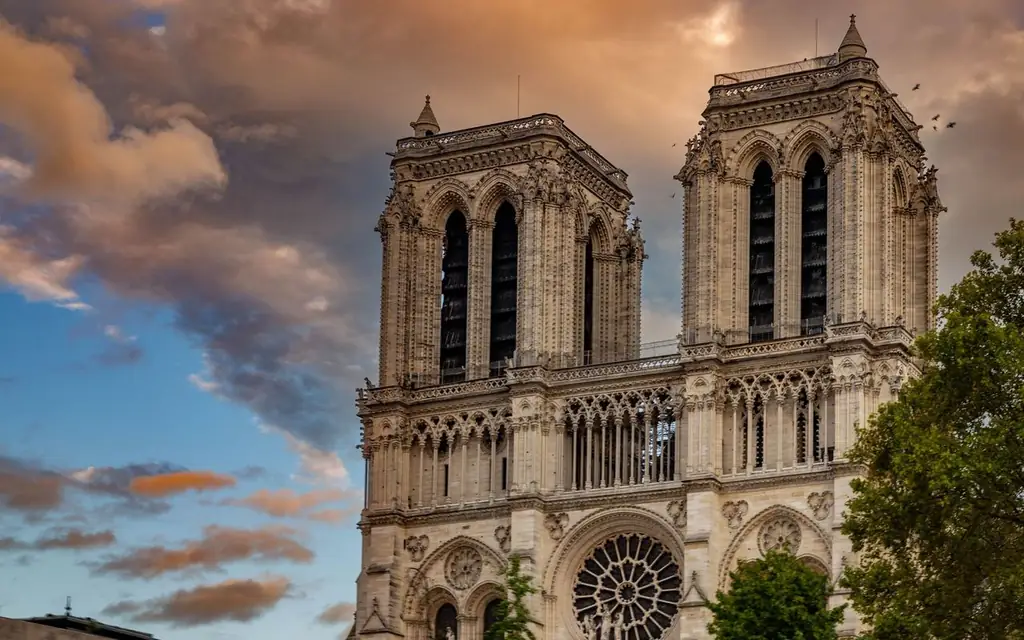 The iconic Notre-Dame Cathedral captured at sunset with dramatic skies in Paris