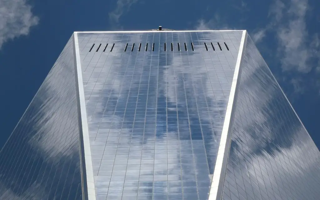 Low angle view of One World Trade Center reflecting clouds in New York City