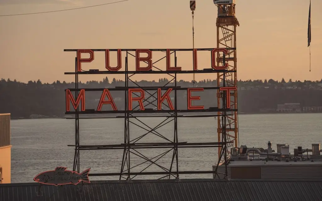 View of the famous Pike Place Market sign in Seattle during a vibrant sunset
