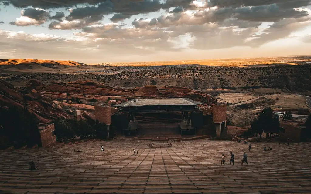 Scenic view of Red Rocks Amphitheatre at sunset in Morrison, Colorado, highlighting dramatic clouds and sandstone formations