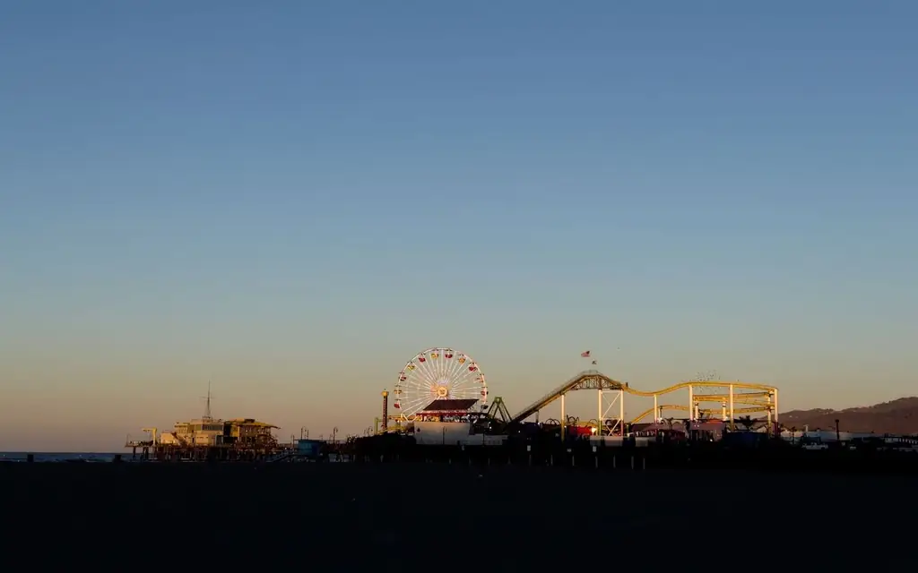Silhouette of Santa Monica Pier featuring a Ferris wheel during a serene sunset in California