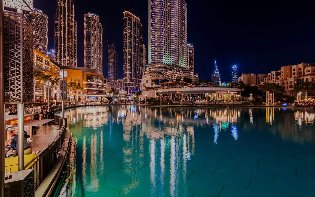 Captivating night view of Dubai's cosmopolitan skyline reflecting in a serene pond