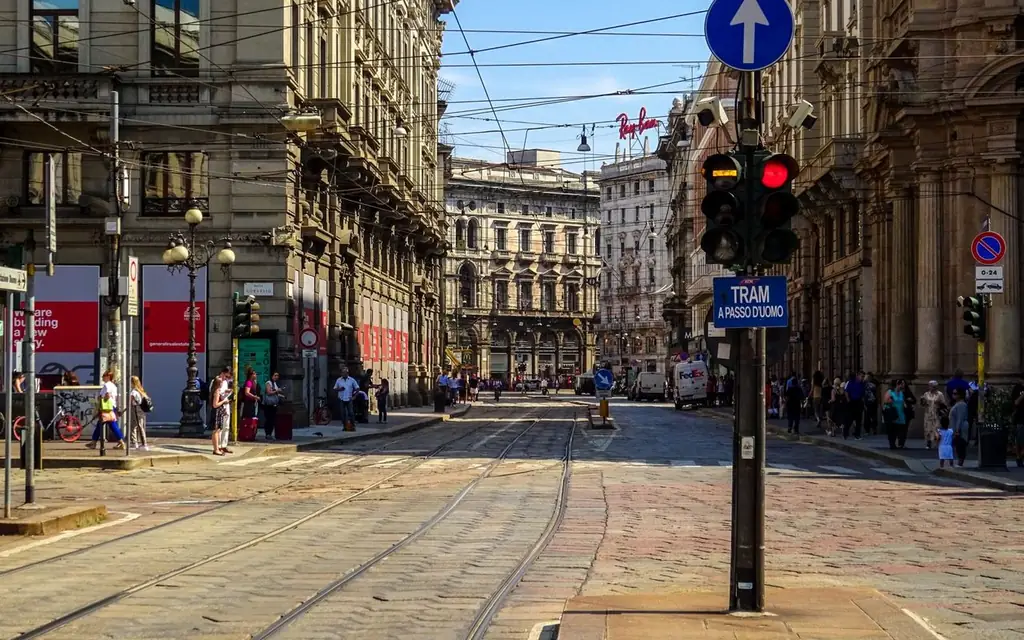 View of a busy street in Milan, Italy showcasing historic architecture and tram lines