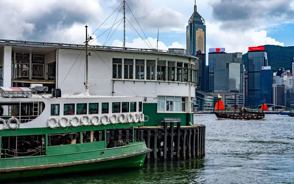 A vibrant scene at the Tsim Sha Tsui Star Ferry Pier capturing a ferry against the city skyline
