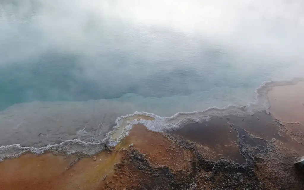 A mesmerizing view of a steaming geothermal pool in Yellowstone National Park, USA