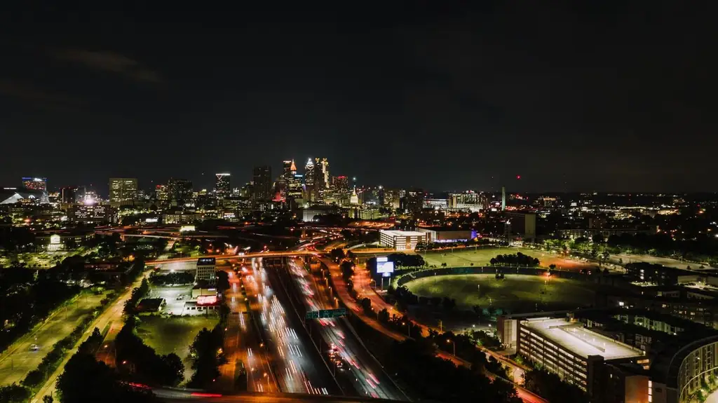 Aerial view of Atlanta city skyline at night with vibrant light trails on highway