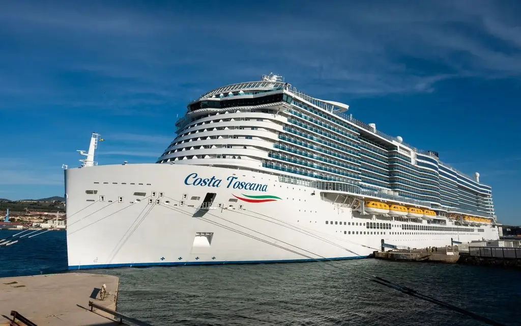 The Costa Toscana cruise ship docked at port under a clear blue sky, ready for passengers