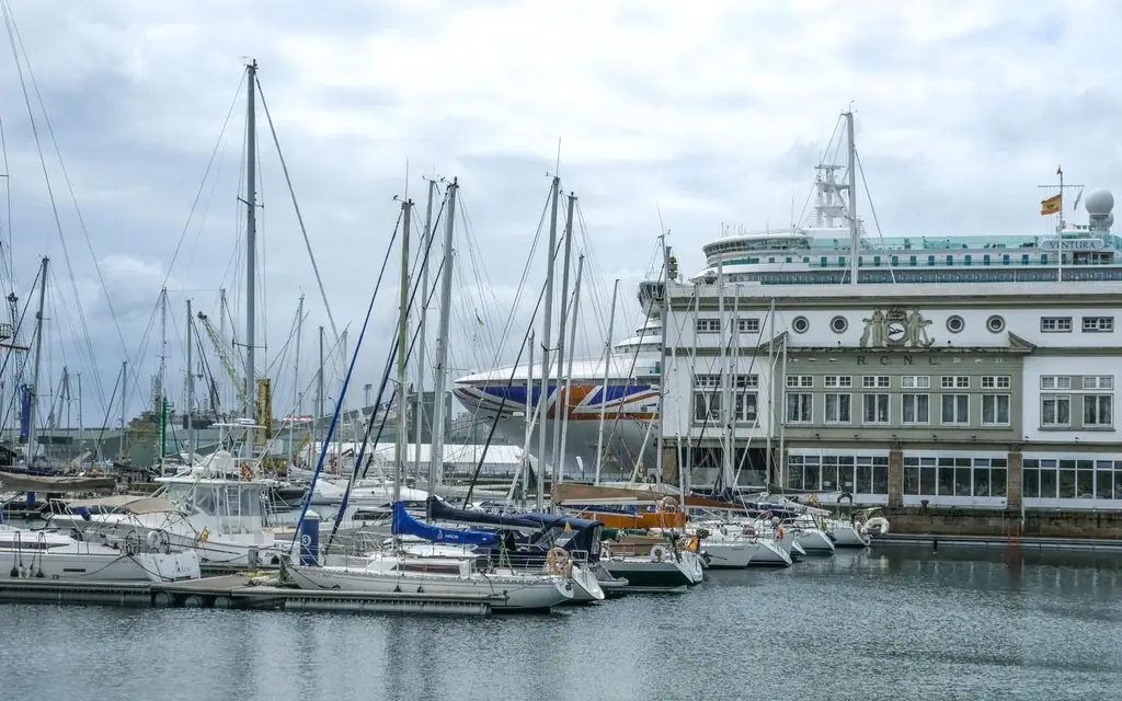 A cruise ship and sailboats in port