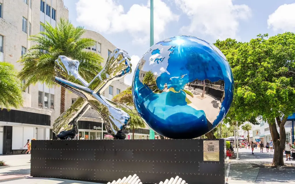 Colorful globe sculpture with metallic X on a sunny Miami Beach street