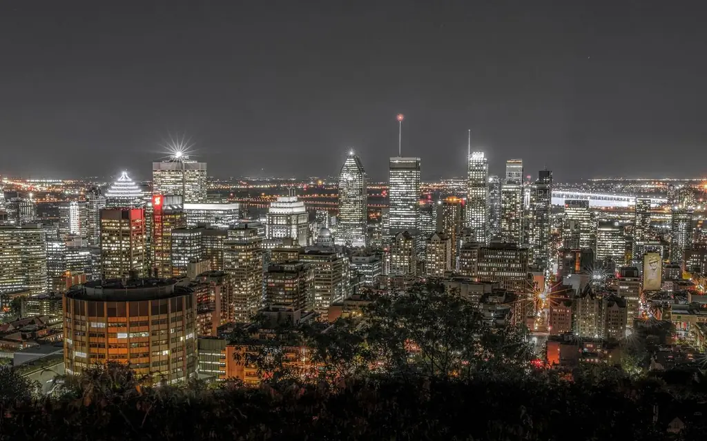 Vibrant nighttime view of Montreal's illuminated skyline, showcasing skyscrapers and city lights