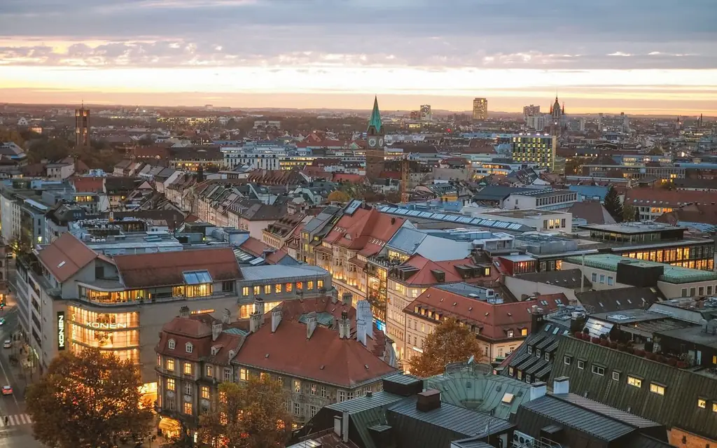 A stunning aerial view of Munich at sunset, showcasing the city's skyline and architecture