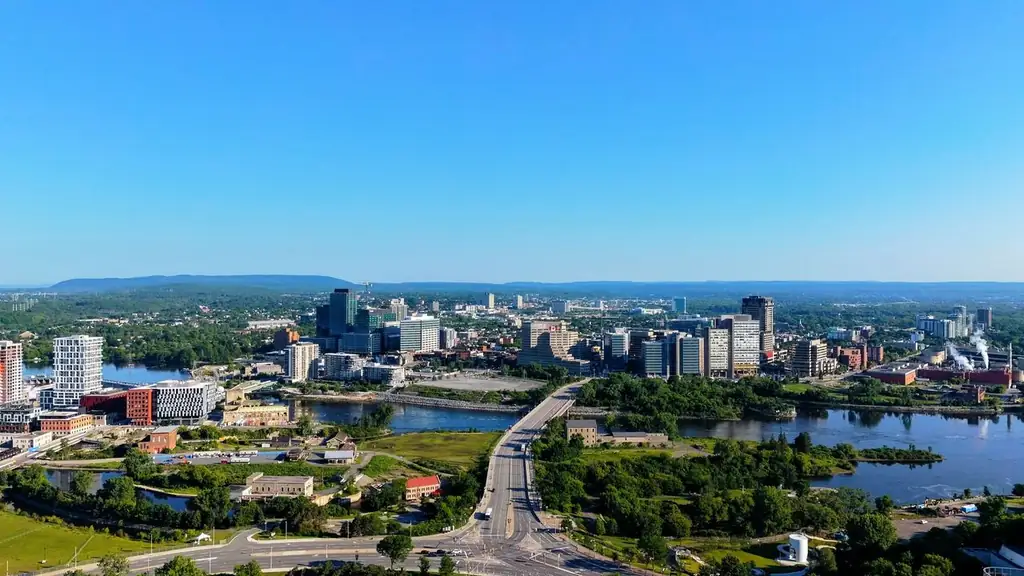 A clear aerial view of Ottawa's skyline showing buildings, greenery, and a river