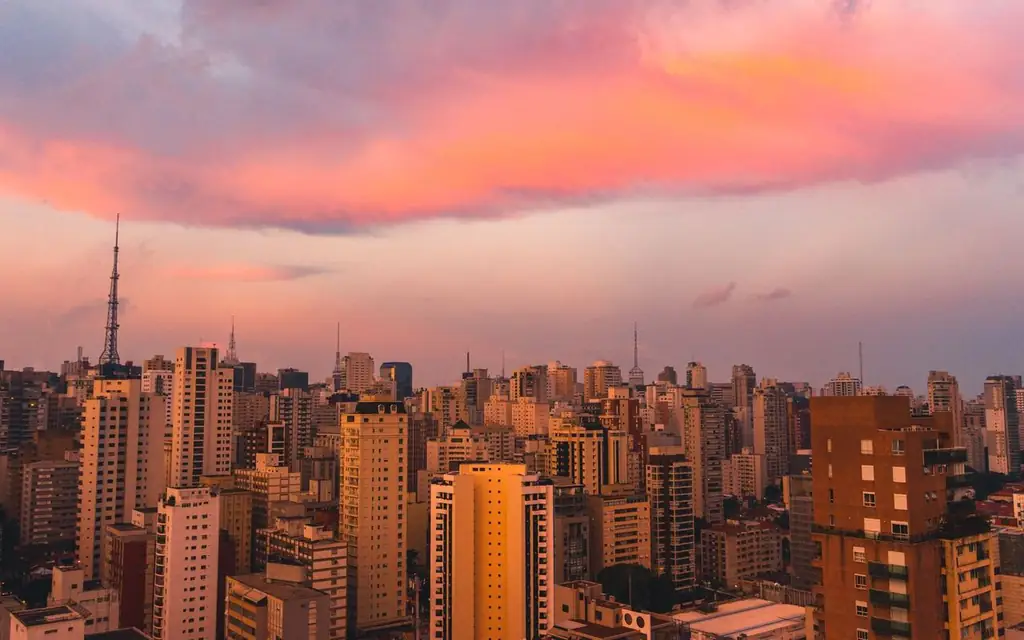 A breathtaking view of São Paulo's skyline at dusk, featuring vibrant pink and orange clouds