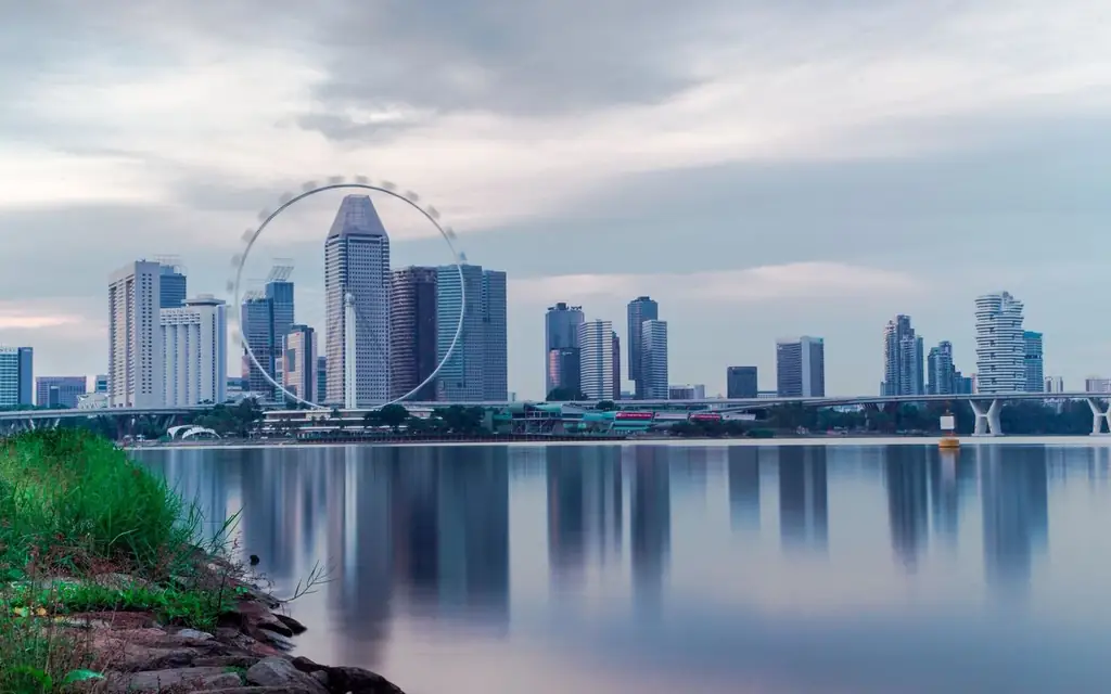 Captivating view of Singapore's skyline featuring the iconic Singapore Flyer reflecting over calm waters