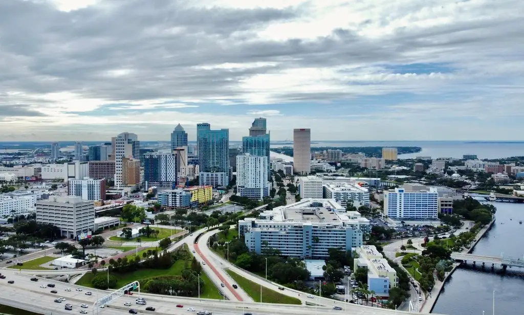 A stunning aerial view of Tampa, FL cityscape featuring modern skyscrapers against clouded skies