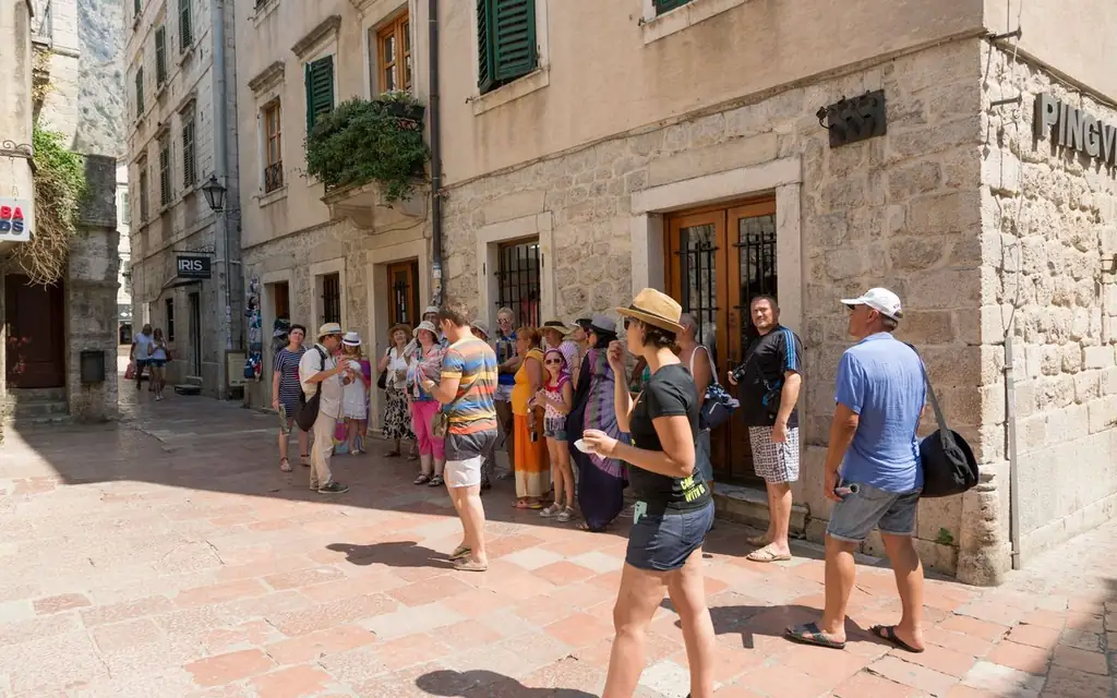 Tourists explore historical European town's vibrant streets on a sunny day, capturing local architecture